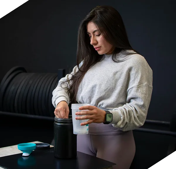 Athlete filling a shaker bottle in the gym